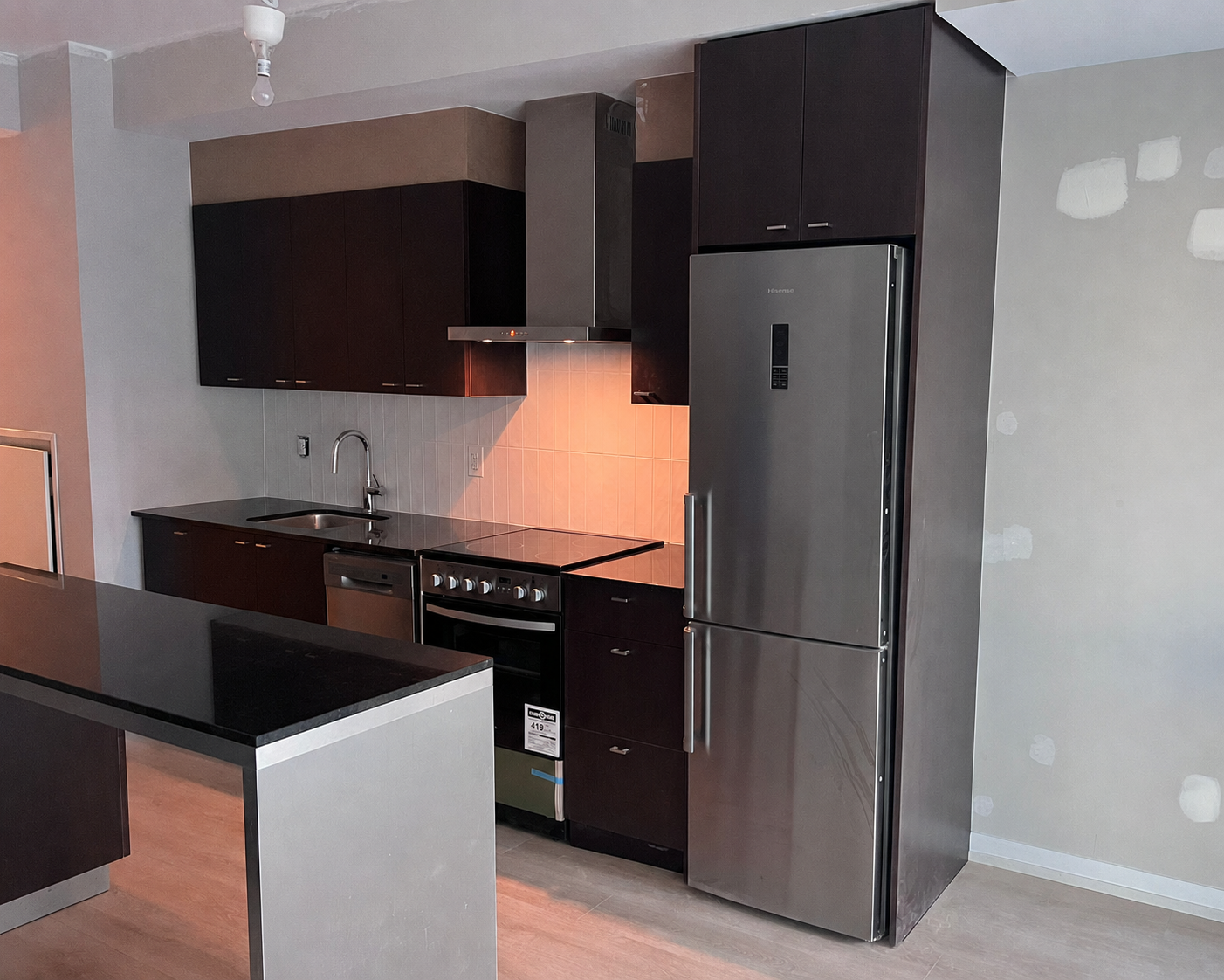 Kitchen with dark cabinets before House of Wrap vinyl installation